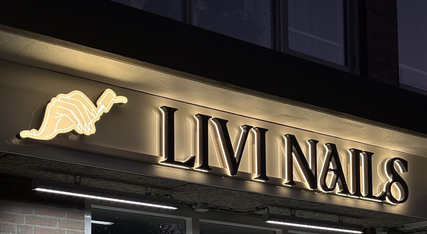 De verlichte letters LIVI NAILS met de hand uit het logo boven de winkel aan de Koningshof
